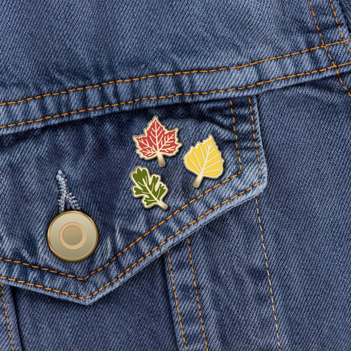 Autumn leaf enamel pins on denim jacket