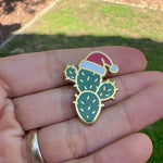 Load and play video in Gallery viewer, Christmas Cactus Enamel Pin with Santa Hat | Holiday Desert Plant Lapel Pin | Festive Cactus Badge | Stocking Stuffer Gift
